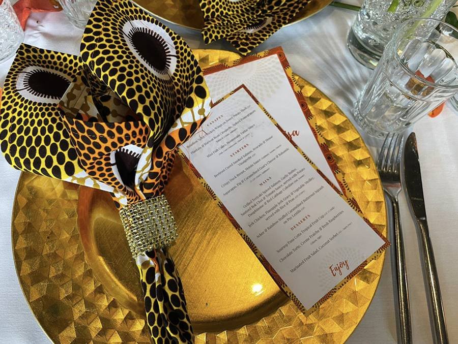 A bespoke printed Park's Edge event menu on a gold charger plate with patterned napkin